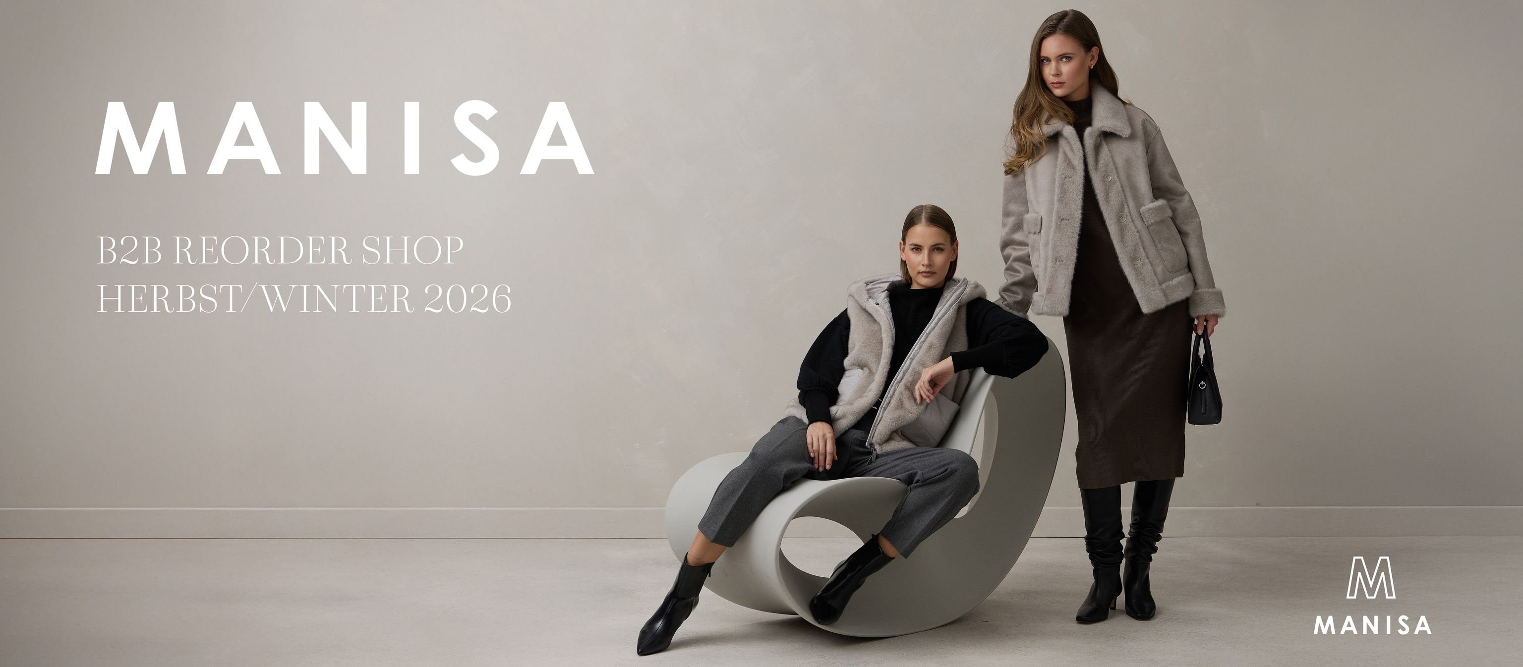 Zwei Personen sitzen lässig auf einem Ball, tragen Winterjacken und lächeln für Manisa Herbst-Winter-Kollektion.